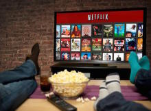 Persone sedute sul divano che guardano Netflix